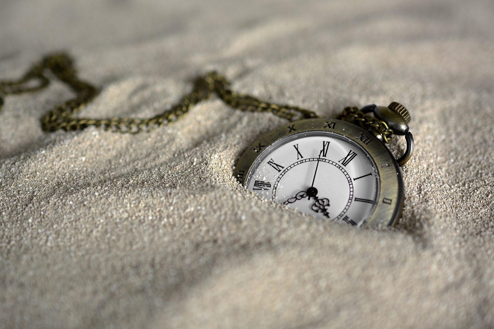Zegarek kieszonkowy leżący na piasku